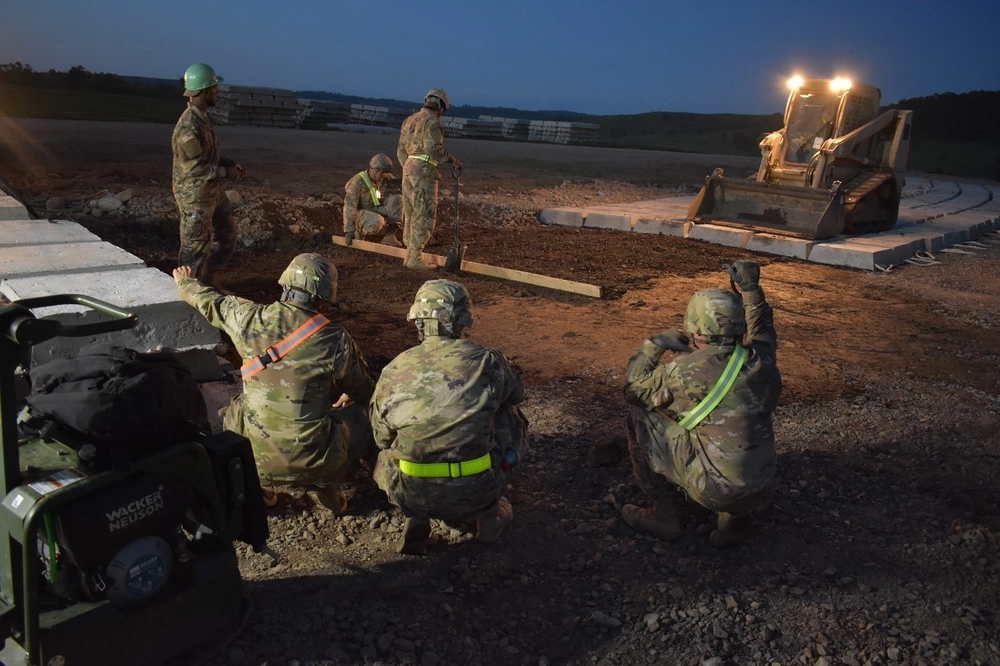 Night operations crew preparing mission-critical track loader on job site